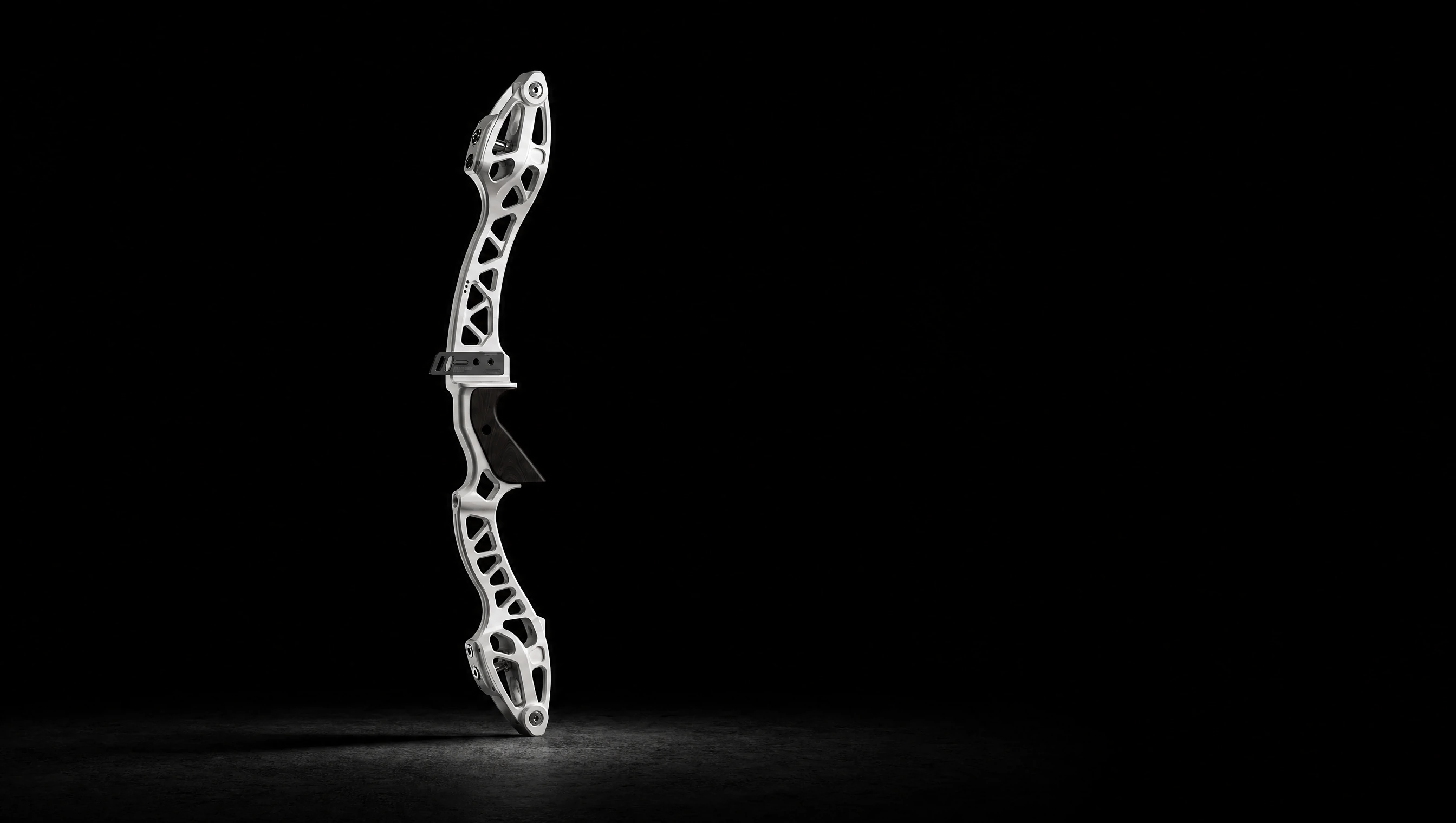Denton Archery riser standing in a dark studio